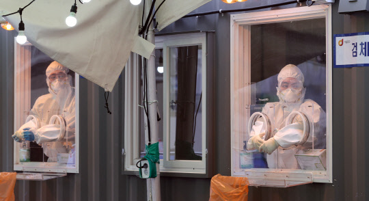 11일 오전 서울역 광장에 마련된 코로나19 임시 선별검사소에서 의료진이 검체채취를 위해 대기해 있다. 연합뉴스